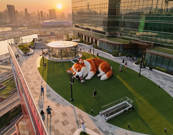 mochi the giant inflatable corgi on top of the Megabhox rooftop, with the Hong Kong skyline at sunset in the background