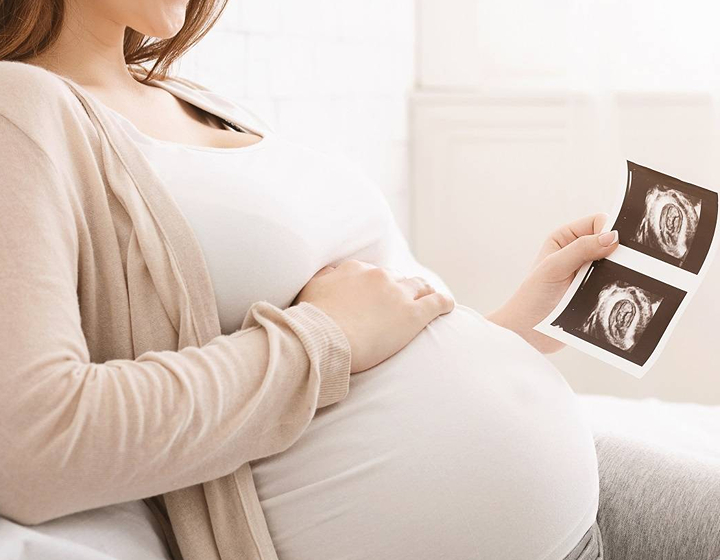 pregnant woman looking at her ultrasound pictures in Tseun Wan Adventist Hospital in Hong Kong