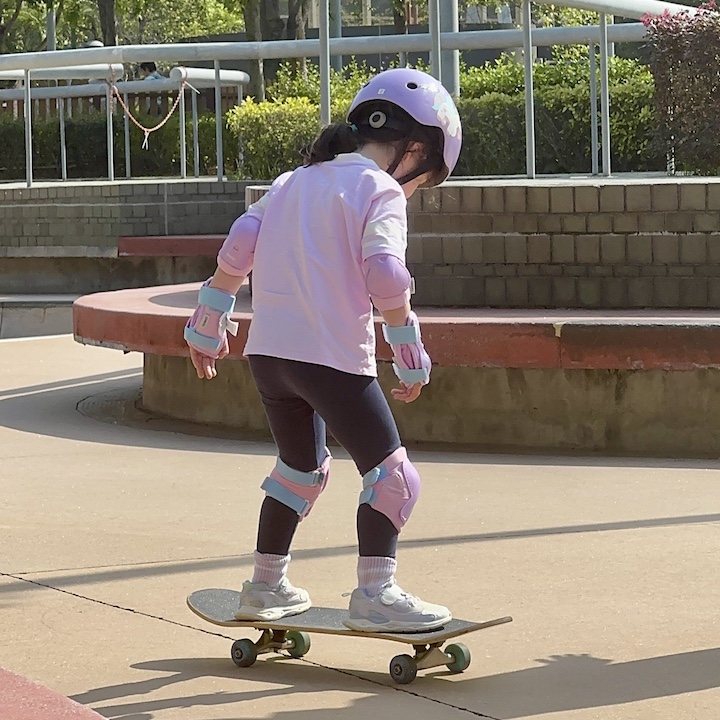 a young girl learns to skateboard at the skate park inside tko velodrome park 