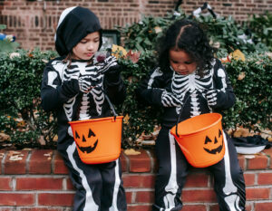 Two kids dressed as skeletons with baskets for trick or treating, dressed in Halloween costumes Hong Kong