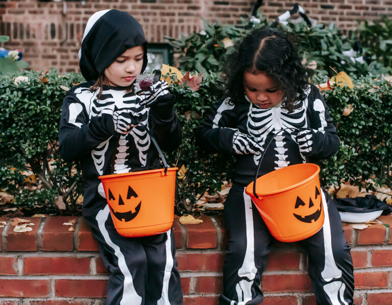Two kids dressed as skeletons with baskets for trick or treating, dressed in Halloween costumes Hong Kong