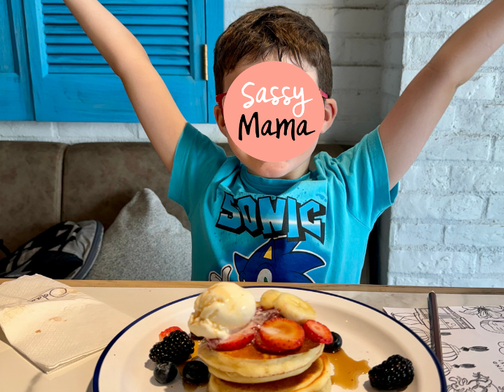 a boy with logo covering face enjoying pancakes for breakfast at oolaa restaurant in tseung kwan o 