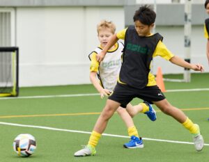 two students play football at bvb academy at German Swiss international School Hong Kong