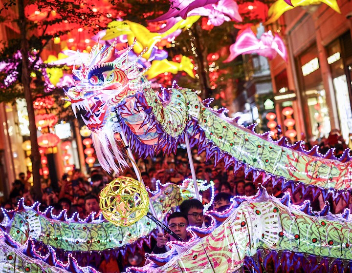 LED Fire Dragon in Lee Tung Avenue Hong Kong surrounded by people at night celebrating Mid Autumn Festival
