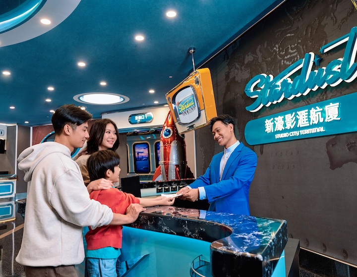 father mother and child at entrance of Studio City Stardust with receptionist in Macau