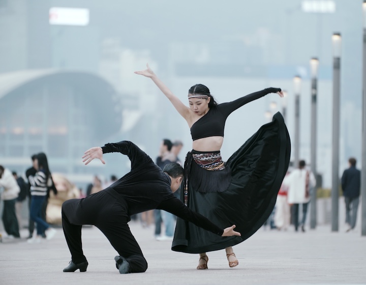 Woman and man dressed in black dancing in the harbour front in Hong Kong as part of the Hong Kong Performing Arts Expo 2026