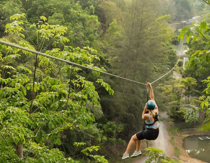 a teenager on a zip line through the rainforest at Anantara Layan resort phuket