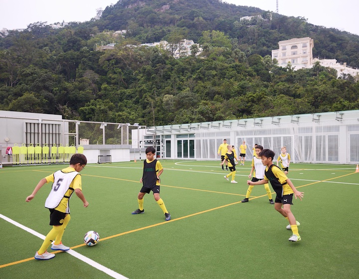 children play football on the pitch at gsis Hong Kong as part of The BVB football academy
