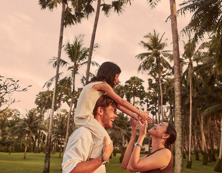 a happy family plays under palm trees at club med phuket all inclusive resort