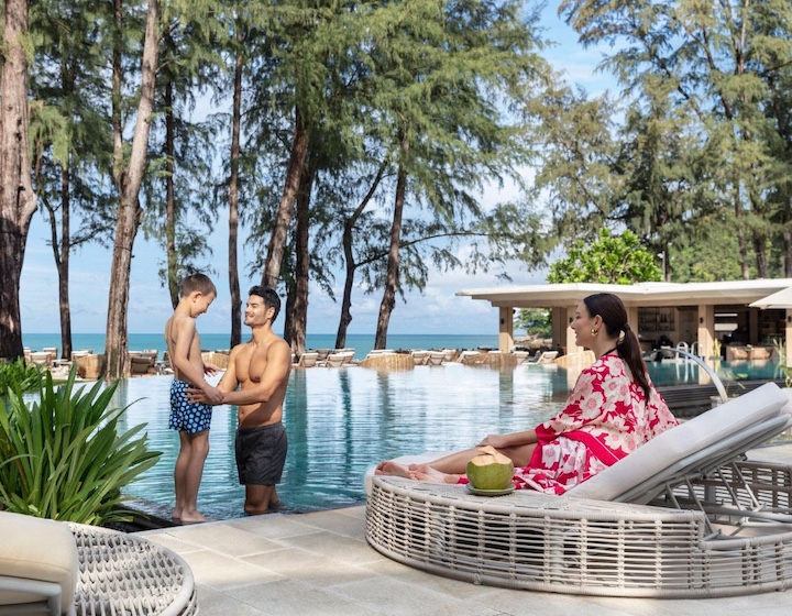 a family relaxes by the pool on a family vacation at the intercontinental phuket luxury resort