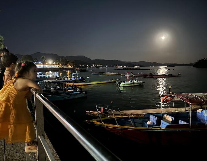 a child looks at the full moon from the waterfront in Sai Kung during the Hong Kong mid-autumn festival