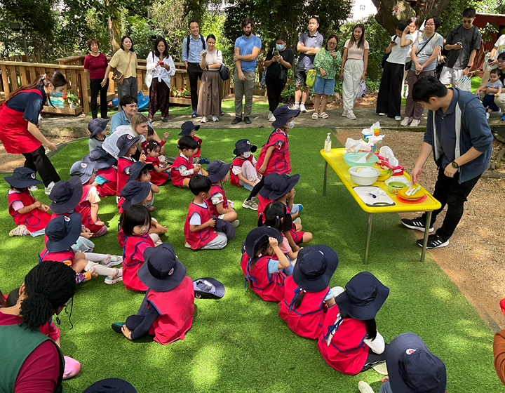 Students, parents and teachers outside during an open day at Norwegian International School