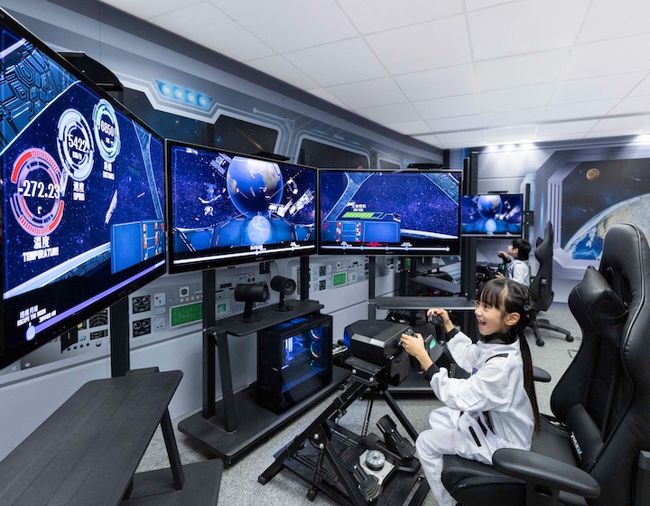 a little girl pretends to be an astronaut on a space simulator game at Noah's ark amusement park in Hong Kong