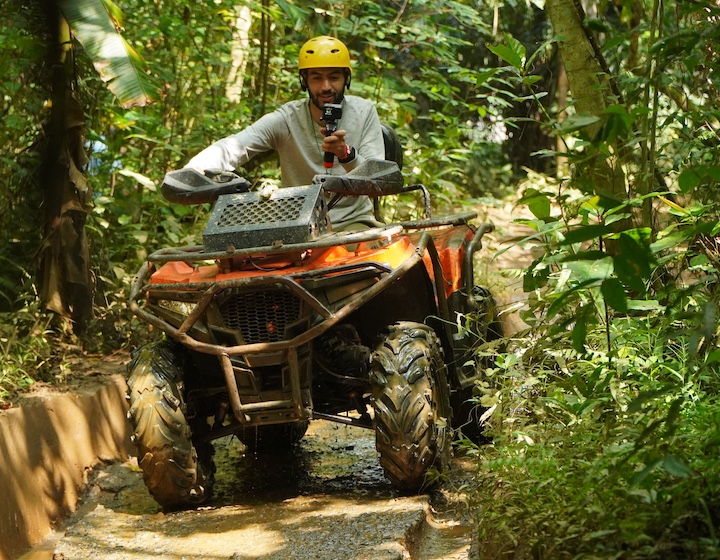 a young man rides an atv through the rainforest in Phuket