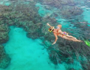 Happy family - mother, kid in snorkeling mask dive underwater, explore tropical fishes in coral reef sea pool. Travel active lifestyle, beach adventure, swimming activity on summer holiday with child.