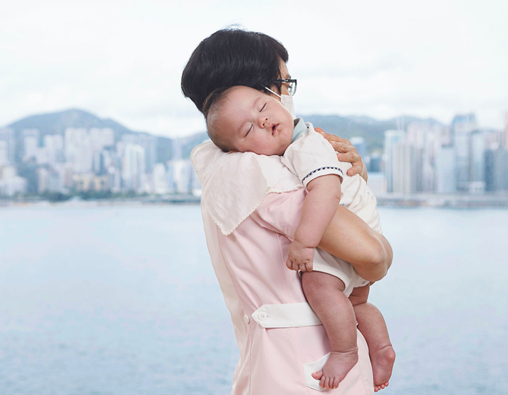 Pui yuet from Tin Yan holding a sleeping baby in Hong Kong