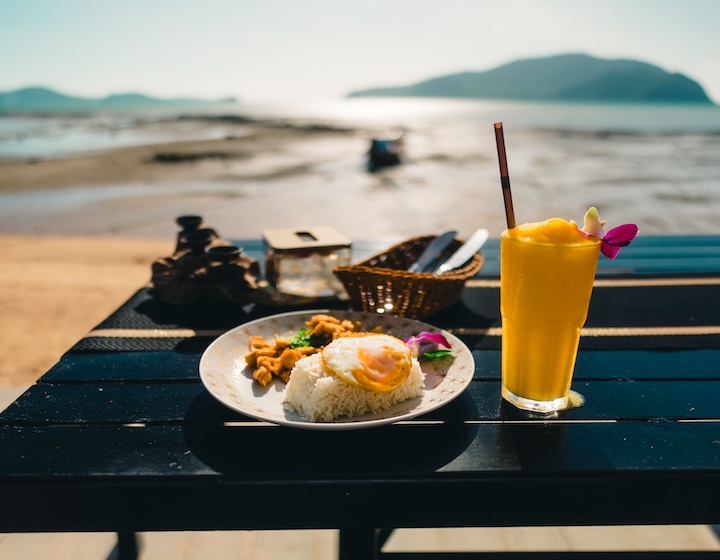 a Thai dish and mango smoothie served on the beach in Phuket