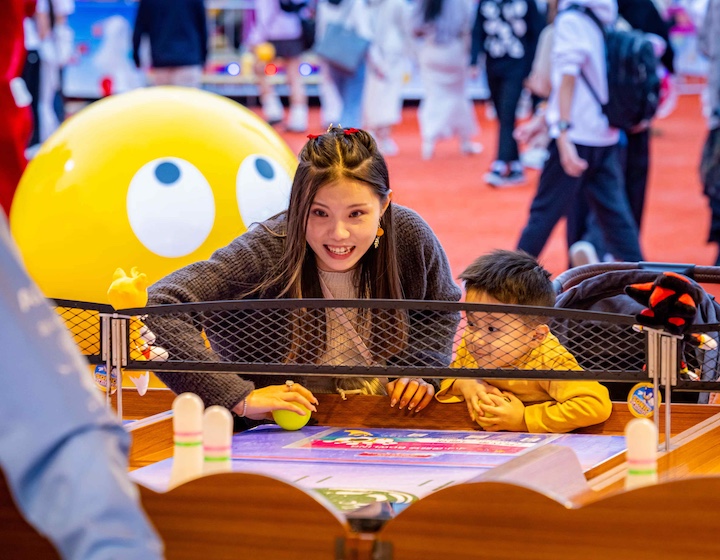 a mother and son play carnival games at the Hong Kong winter fair