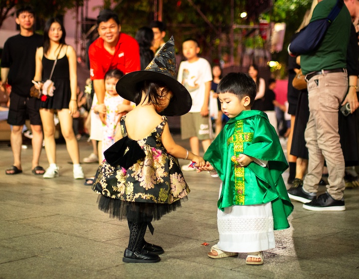 asian children exchanging candy while trick-or-treating in Hong Kong