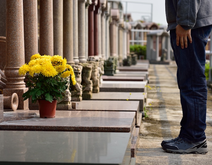 a Hong Kong man leaves flowers on a grave during Chung Yeung festival