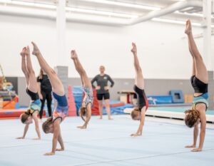 a group of gymnasts practising handstands