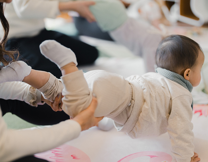Baby being stretched and played with by parent at Little baby class in Hong Kong