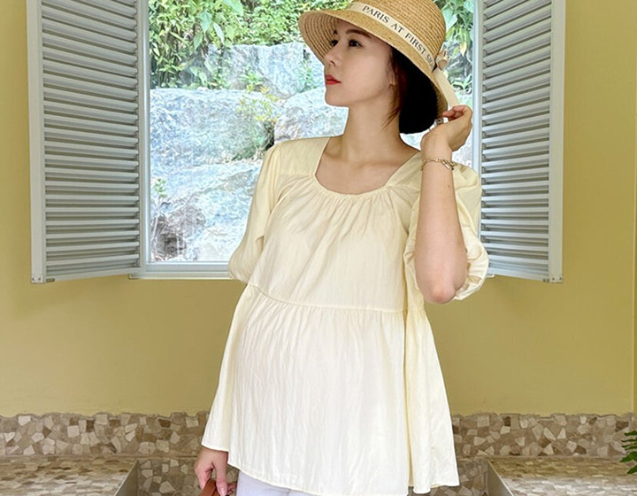 Woman wearing comfortable maternity clothes from Milky Mama Hong Kong, yellow maternity top and white shorts