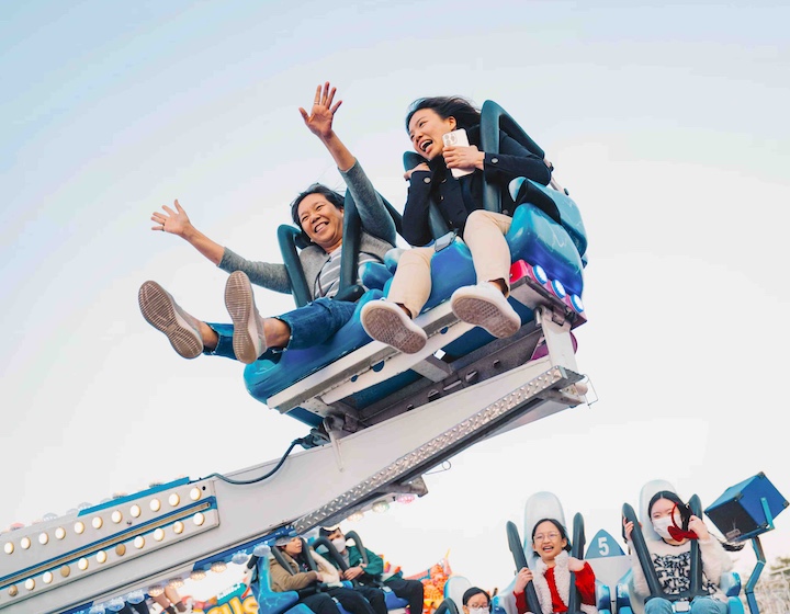 two women riding the thrill attractions at Hong Kong's AIA Carnival