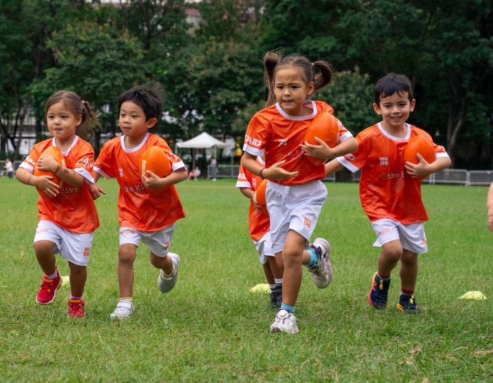 toddlers run with footballs at mini-sports Hong Kong summer camps for kids in 2026
