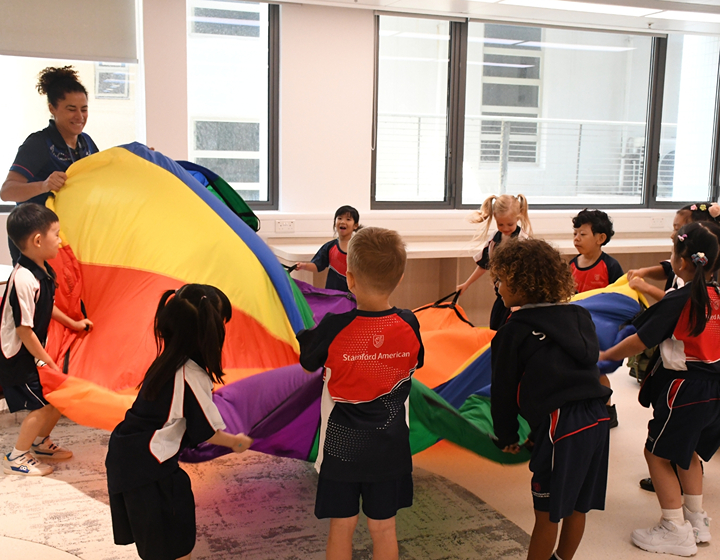 Stamford American School students playing the rainbow game with their teacher in the Ho Man Tin campus