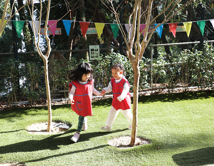 two kids playing in the outdoor garden at Small World Christian Kindergarten in Hong Kong