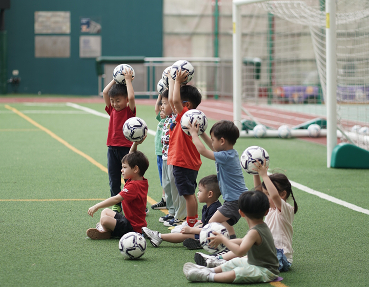 Toddlers with footballs in a LionRock Sports playgroup in Hong Kong