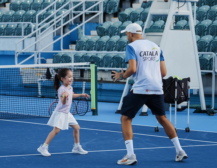 a Hong Kong girl takes tennis lessons with a coach from catala sports