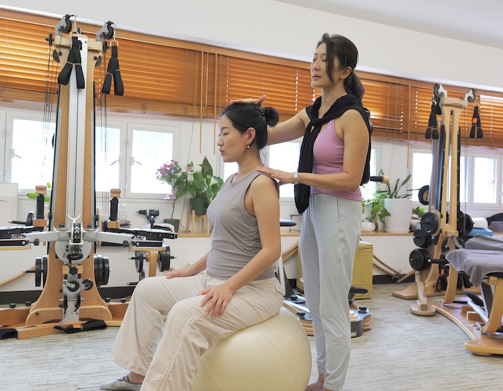 pregnant woman sits on a fit ball during a prenatal fitness class at isofit Hong Kong