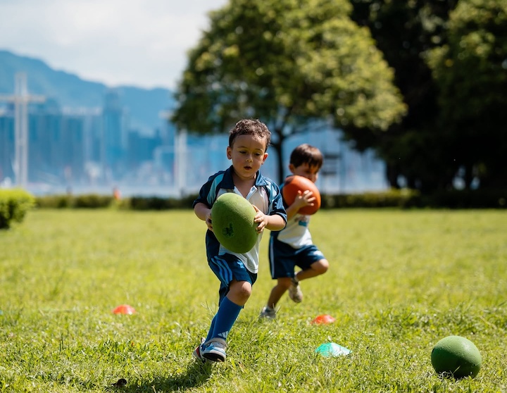 a young boy plays rugby tots after school in Hong Kong